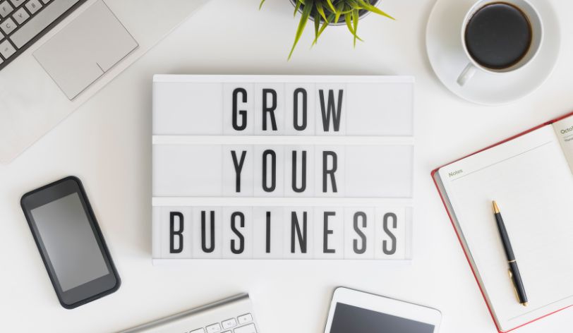 How To Promote Your Website - Desk with words Grow Your Business